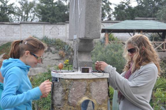 Tentando colocar o ovo em pé na Linha do Equador, no museu Intiran, em Mitad del Mundo, no Equador